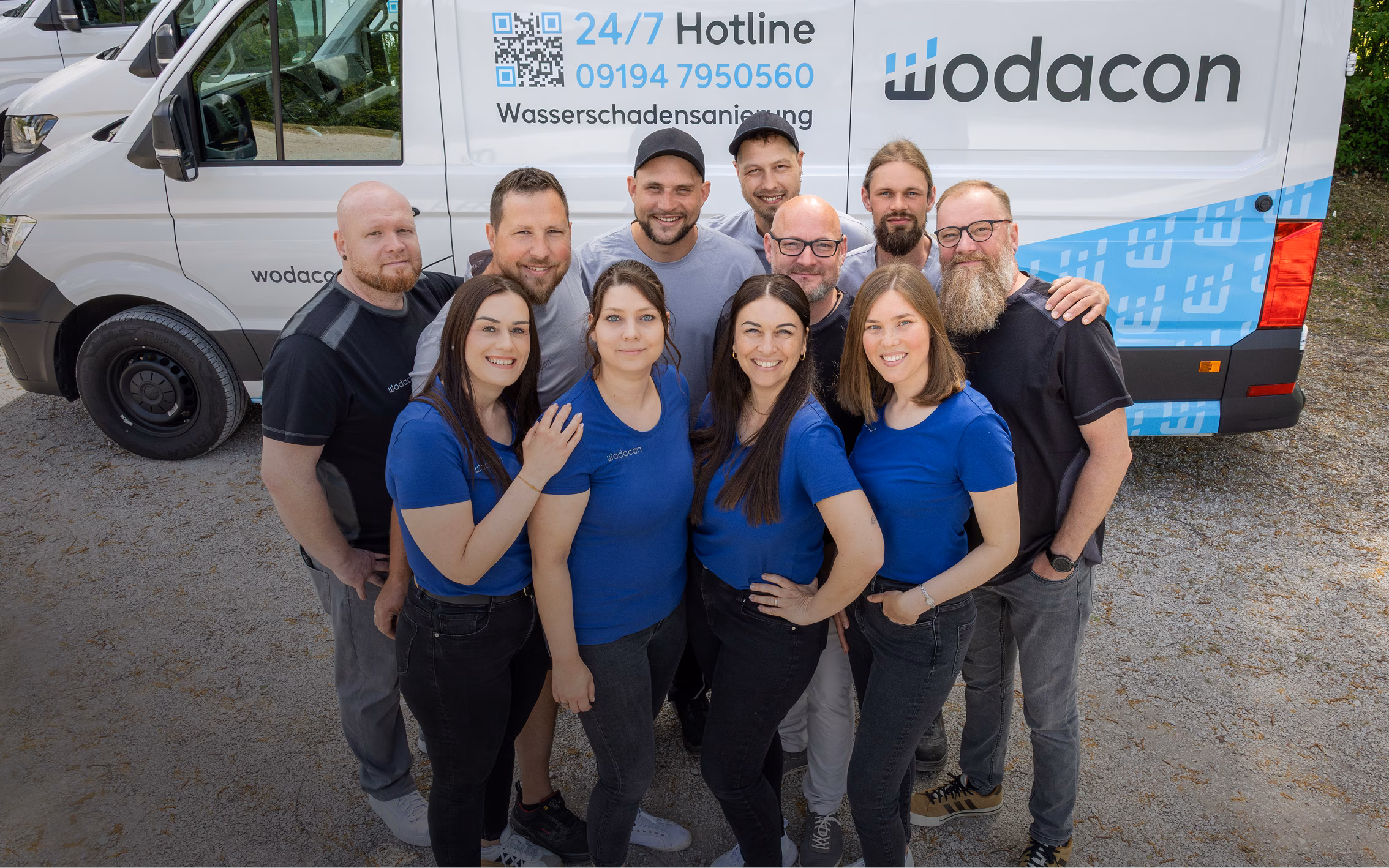 Team von wodacon in T-Shirts mit Logo vor einem wodacon Lieferwagen mit der Aufschrift Wasserschadensanierung